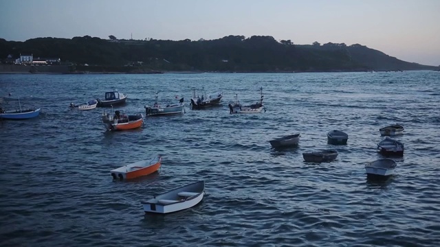 在夜景中，根西岛的海岸线上停泊着几艘空船视频素材