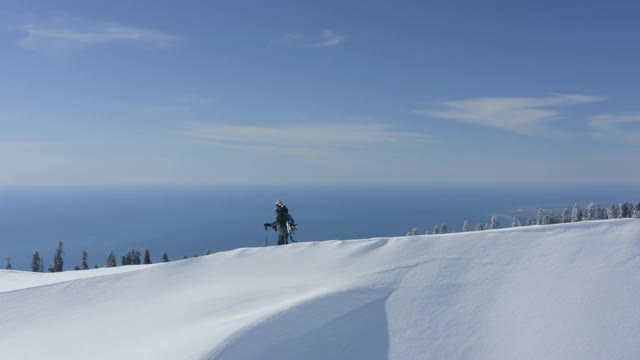 滑雪板攀登雪峰的冬季高山与海洋景观视频素材