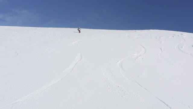 滑雪板上的滑雪板在雪坡在冬季山鸟瞰图视频素材