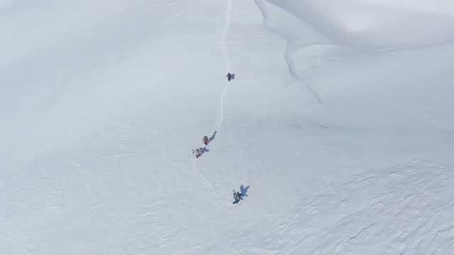 成群的滑雪板徒步旅行在雪山免费乘车。天线上视频素材