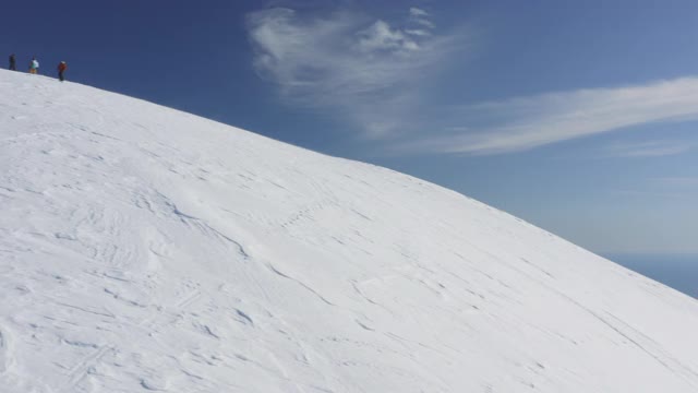 女孩骑着免费滑雪板摔倒在山坡鸟瞰图视频素材