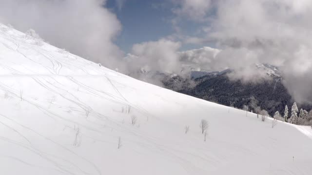 滑雪者乘坐免费滑雪从雪坡在冬季山鸟瞰图视频素材