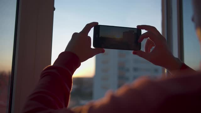 男人拿着手机，在夕阳下起飞视频素材