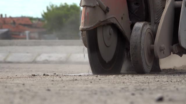 建筑工人正在为人行道切割沥青路面视频素材