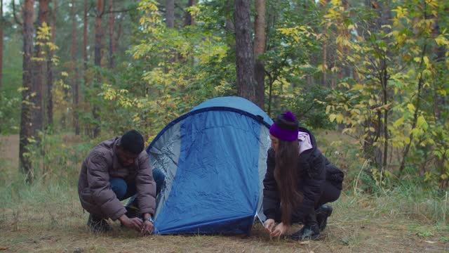 跨种族旅行者夫妇在搭建帐篷视频素材