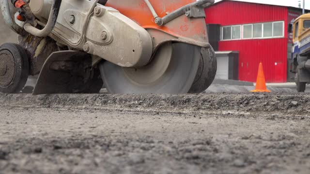 建筑工人正在为人行道切割沥青路面视频素材