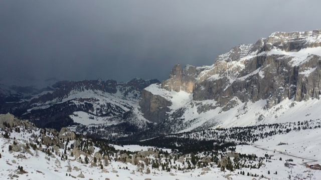 意大利Dolomites无人机拍摄的冬季画面。相机在塞拉山脉和雪云的背景下平稳地升上地面。坎皮特洛迪法沙，特伦蒂诺。视频素材