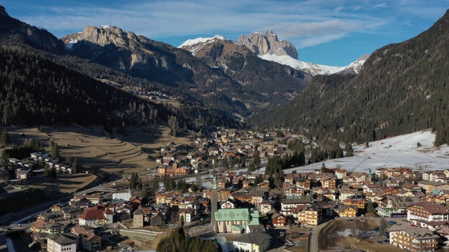 一架无人机在意大利阿尔卑斯山Dolomites山区的Pozza di Fassa村上空飞行。意大利美丽的自然风光。白云石山脉冬天lanscape视频素材