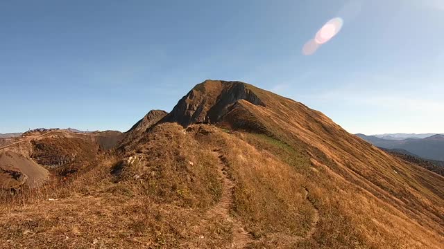 五彩斑斓的山景在秋天是金色的。美丽的秋景森林在群山中映衬着明亮的蓝天视频素材