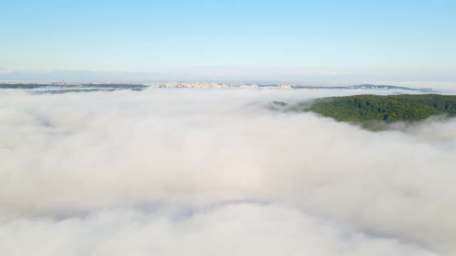 笼罩群山的晨雾。鸟瞰图的绿树覆盖着浓雾视频素材