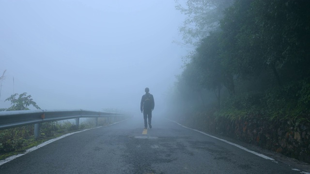 早晨，一个人走在有雾的路上视频素材