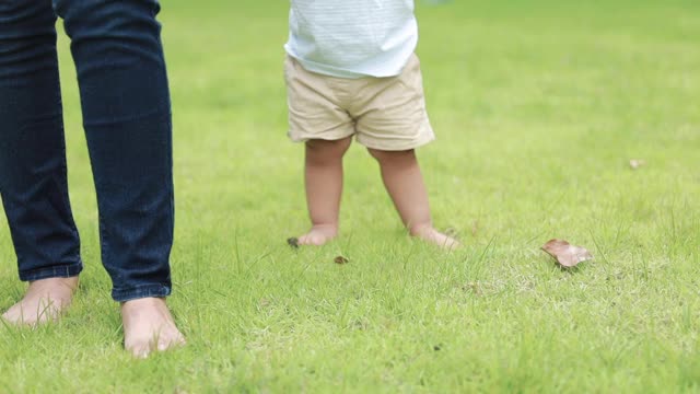 蹒跚学步的孩子开始学走路视频素材