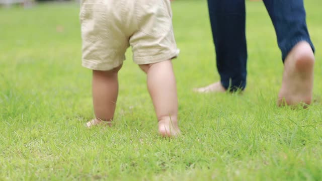 蹒跚学步的孩子开始学走路视频素材