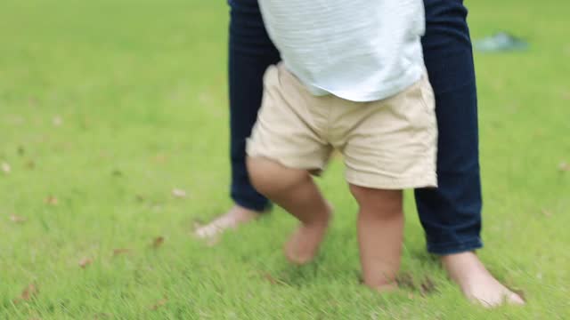 蹒跚学步的孩子开始学走路视频素材