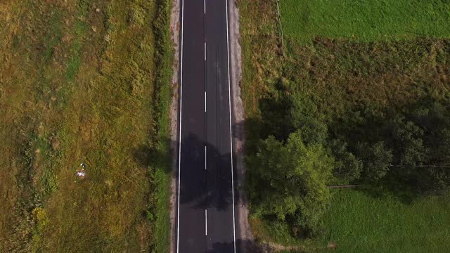 无人机的视野开阔空旷的道路在荒野森林与起伏的山丘和山脉深处视频素材