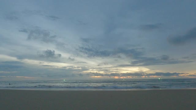 平静的海浪拍打着夏天的海滩，金色的日落，蓝色的天空视频素材