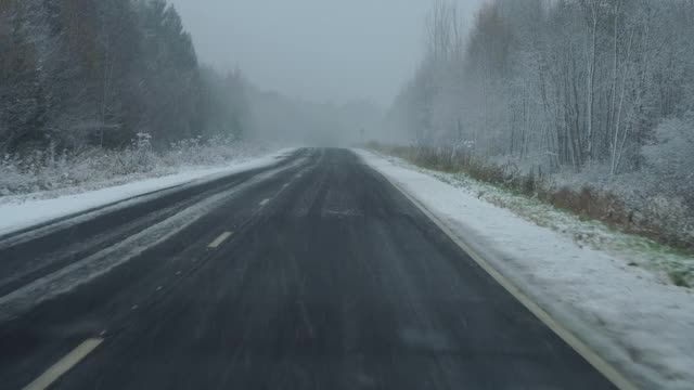 汽车在冬天下雪时行驶在路上视频素材