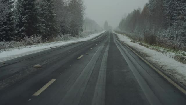 汽车在冬天下雪时行驶在路上视频素材