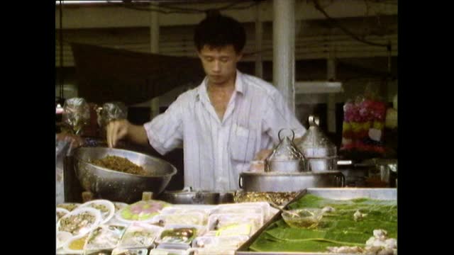 曼谷，一名男性街头小吃小贩正在做煎饼;1989视频素材