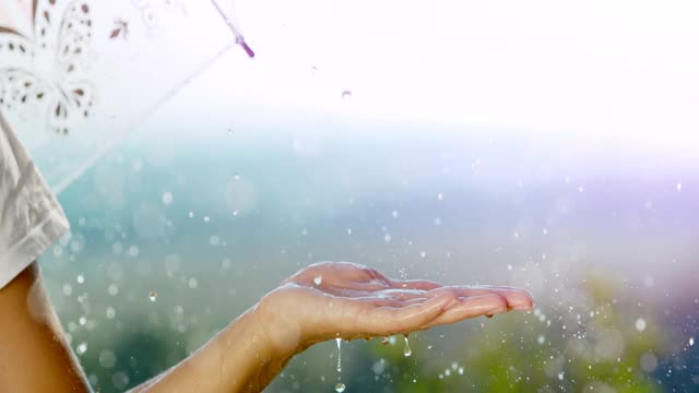 超级SLO MO不认识的女人，她张开手掌对着雨滴视频素材