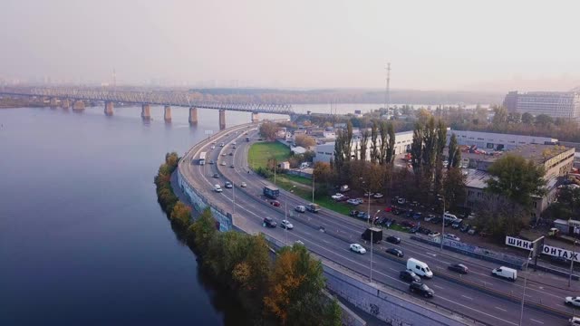 飞过高速公路，沿河而上的工业区对面是秋天乌克兰基辅的一座铁路桥视频素材