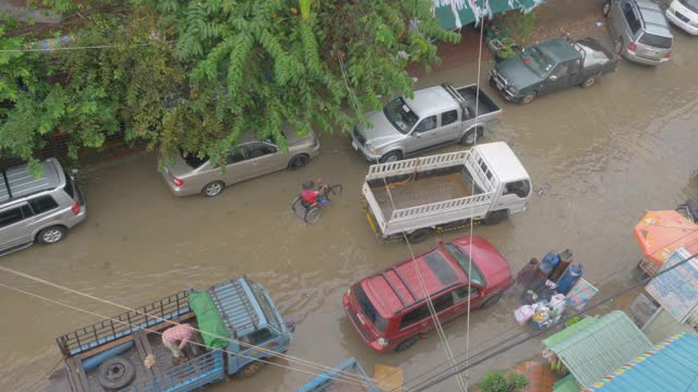 头顶上的车辆和摩托车通过一个小洪水街道视频素材