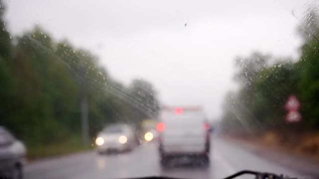 在一个阴雨霏霏的秋日，汽车旅行。雨点落在挡风玻璃上视频素材