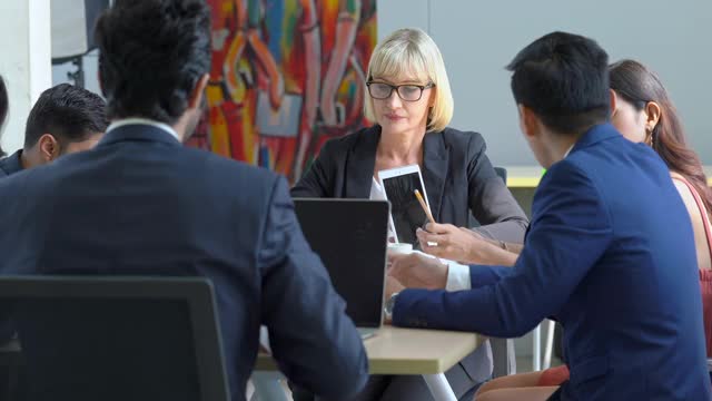 在办公室会议室举行专业多元化的商界人士和商界女性同事团队会议，讨论和头脑风暴商业战略理念，为成功的商业项目视频素材