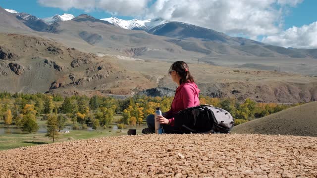 女人在山间徒步旅行时喝茶视频素材