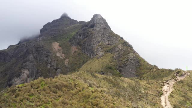 一个长剪辑，显示了巨大的草典型的高地安第斯和一个巨大的岩石山脉的Rucu Pinchincha视频素材