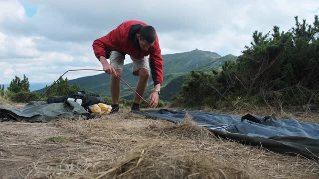 一名游客在山上支起了一个帐篷。徒步旅行。独自旅游视频素材