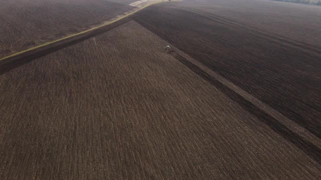 俯视图或鸟瞰拖拉机犁地。农业的概念。4 k决议。视频素材