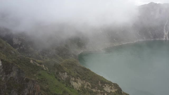 仍有视频显示云层从一座大山的顶部进入，然后向一个湖方向下降视频素材