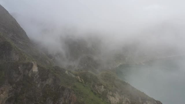 仍有视频显示云层从一座大山的顶部进入，然后向一个湖方向下降视频素材