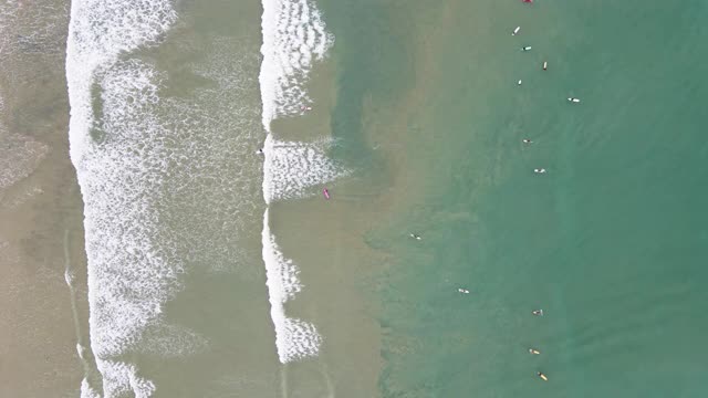 冲浪板上的冲浪者准备赶上海浪的4k空中俯视图视频素材