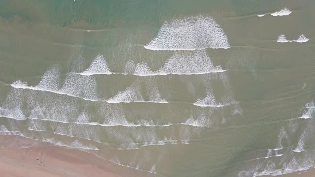 4k空中俯视图的海滩波浪和冲浪者在海里视频素材