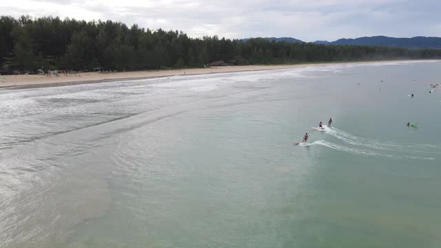 4k鸟瞰图通过冲浪者冲浪在冲浪海滩最大的波浪的多莉视频素材