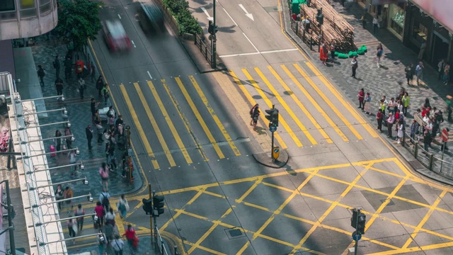 在中国香港尖沙咀区，人们和出租车穿过一个非常繁忙的十字路口视频素材