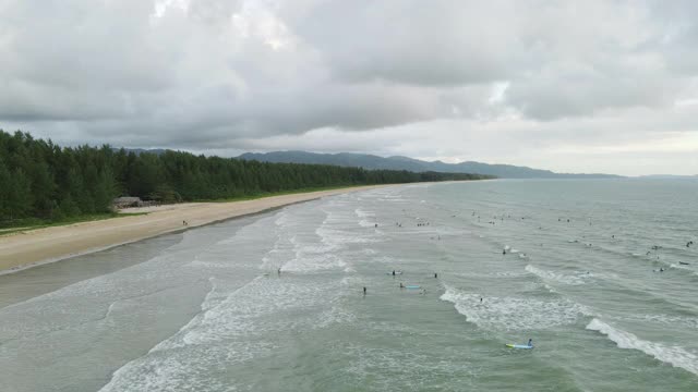 4k架空俯视图倾斜缩放出冲浪者海滩波浪，海浪视频素材