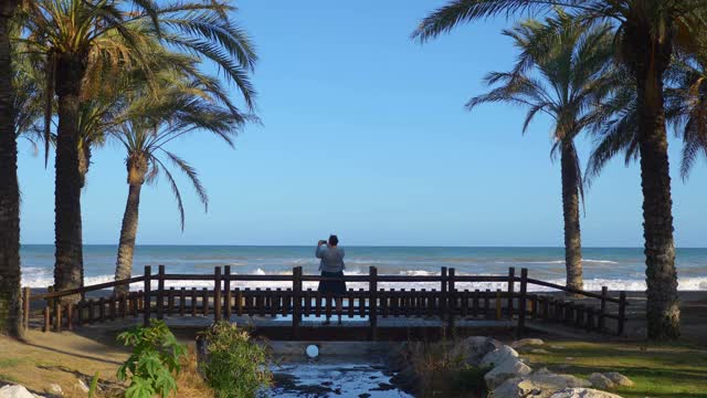 一个女人在西班牙的太阳海岸拍照，4k慢镜头，每秒60帧视频素材