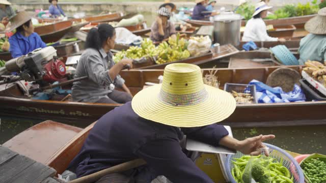 Damnoen Saduak浮动市场或安帕瓦。泰国Ratchaburi区，当地人在运河上出售水果和传统食物。亚洲著名旅游景点。视频素材