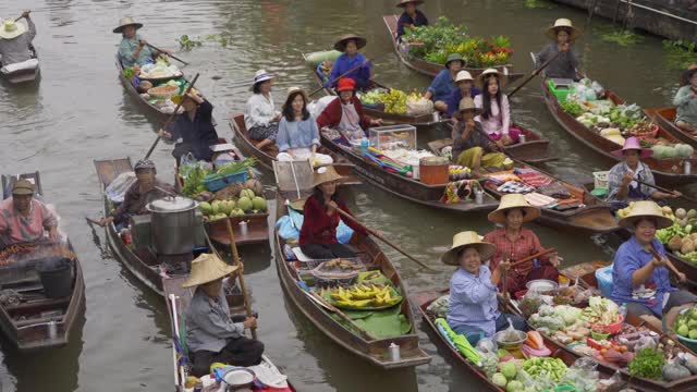 Damnoen Saduak浮动市场或安帕瓦。泰国Ratchaburi区，当地人在运河上出售水果和传统食物。亚洲著名旅游景点。视频素材