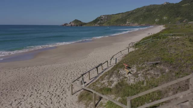 在巴西圣卡塔琳娜Florianópolis的鼹鼠海滩上空的无人机飞行视频素材