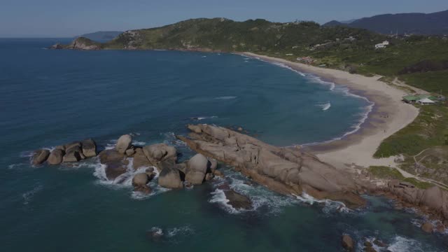 在巴西圣卡塔琳娜Florianópolis的Praia Mole的岩石上，白天的空中降落视频素材