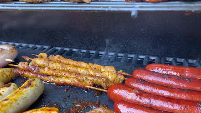 慢镜头近距离拍摄的美味的肉正在烧烤烧烤在后院在夏季聚会。视频素材