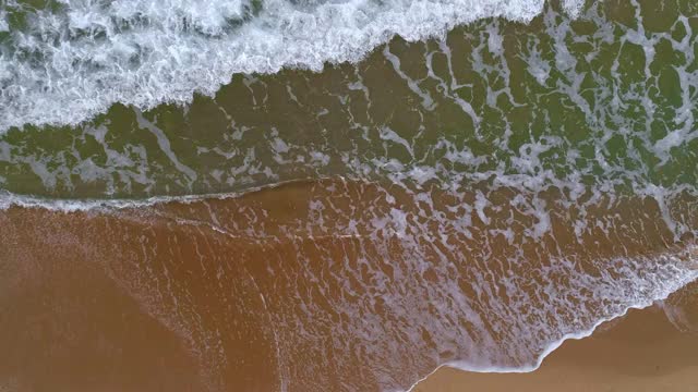 空中俯瞰海面或海浪和沙滩上的黄色沙滩。空中,4 k视频素材