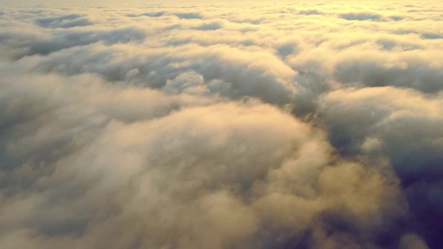 云上的壮观日出。飞过晨雾的天空，阳光照亮了雾和云。背景或纹理。视频素材