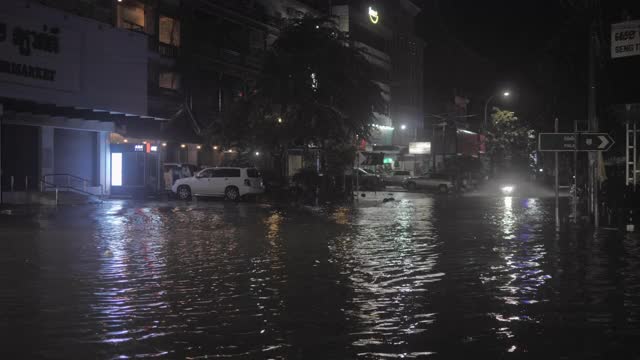 下雨的夜晚，车辆在被水浸透的街道上行驶视频素材