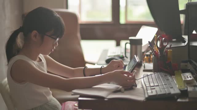 亚裔中国女孩在家学习在她父亲的家庭办公室参加在线课程视频素材