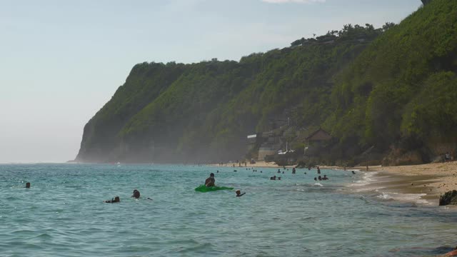 白天时间巴厘岛著名的美拉斯蒂海滩拥挤的海岸线慢镜头全景4k印尼视频素材